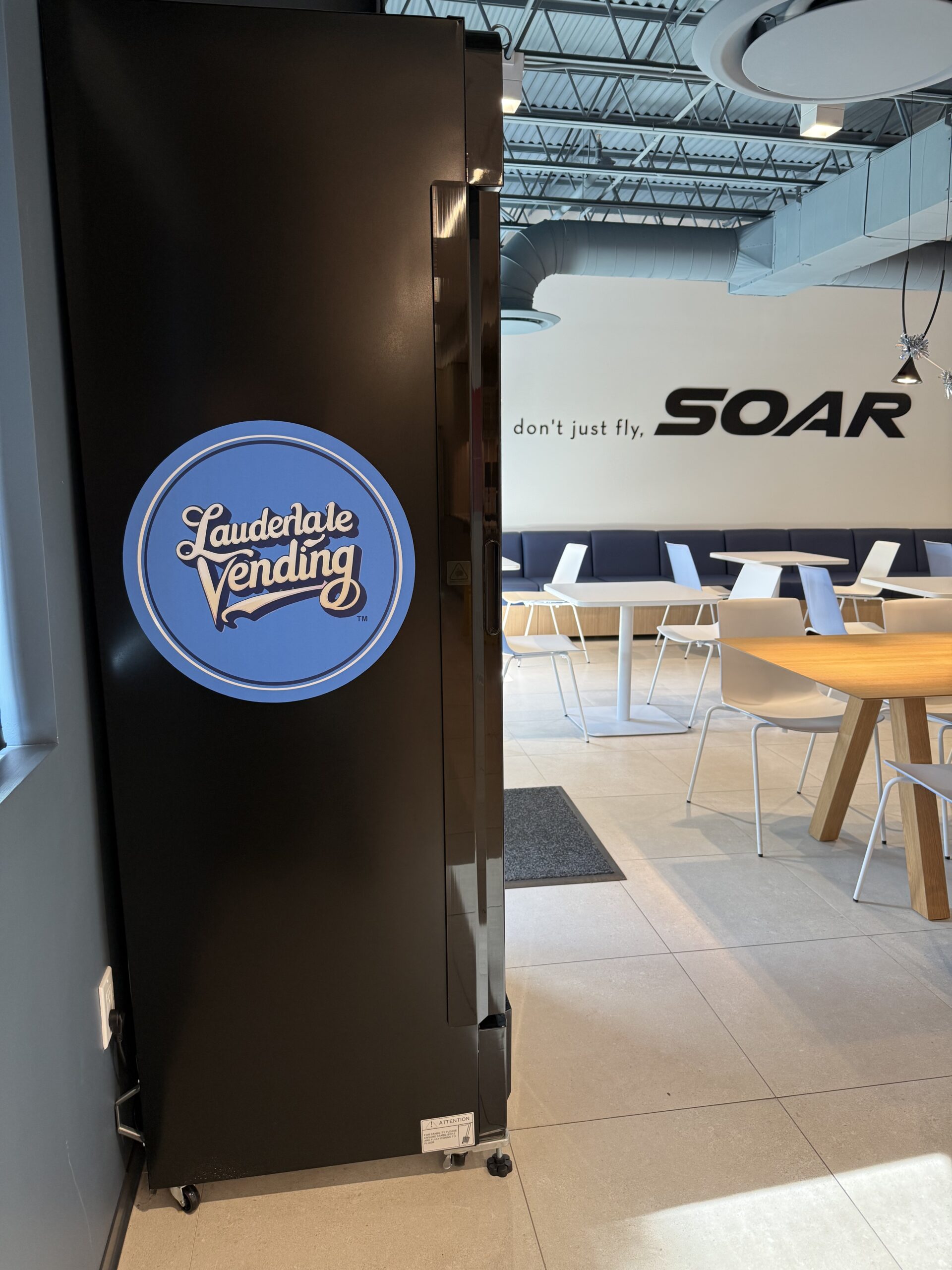 Branded Lauderdale Vending smart cooler in a flight-training lounge